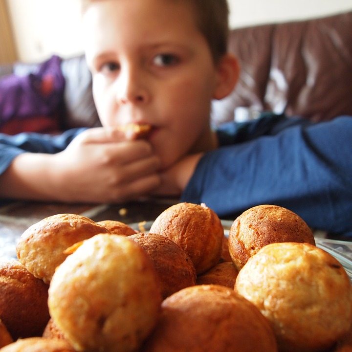 Boy eating a biscuit from a biscuit bowl