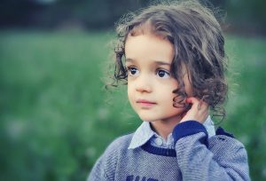 Brown-haired child in a field of grass