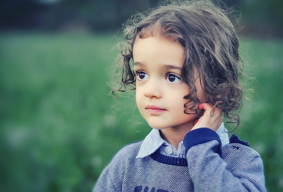 Brown-haired child in a field of grass