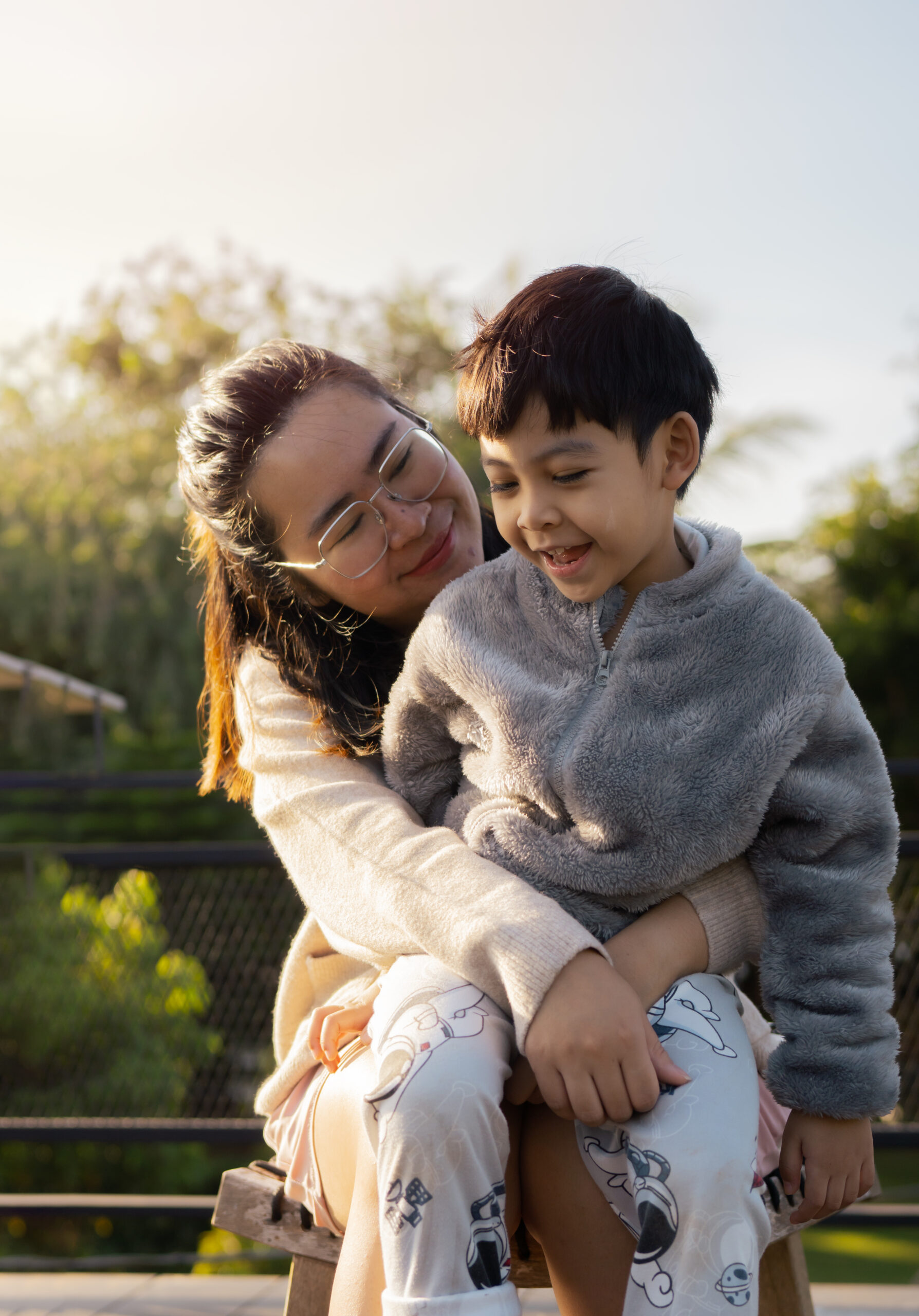 Woman and her son embracing at outdoor in the morning on a summer day.